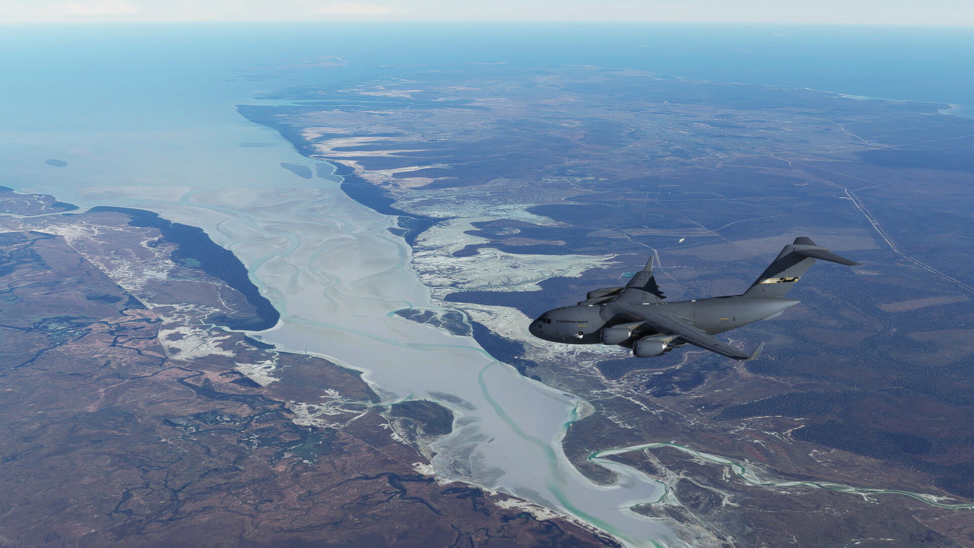 A C17 flying over the mouth of a river