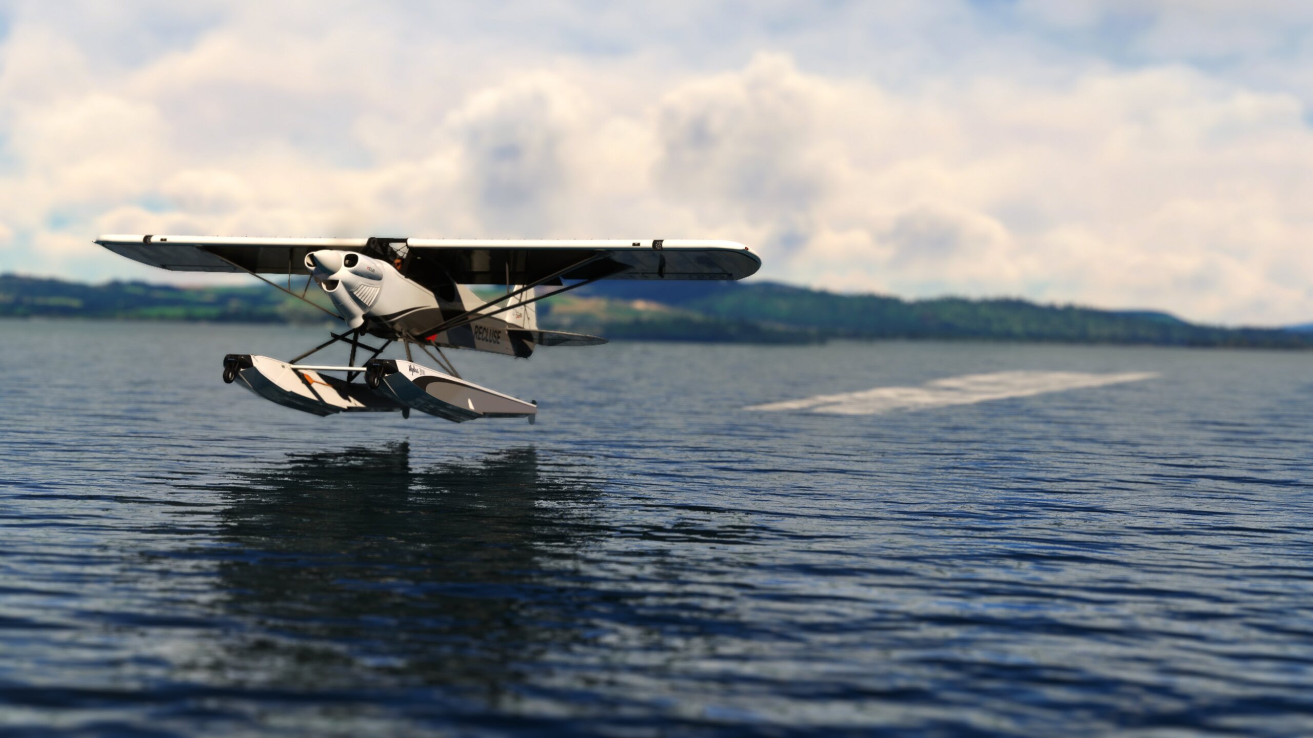 A high wing propeller aircraft departs from a lake