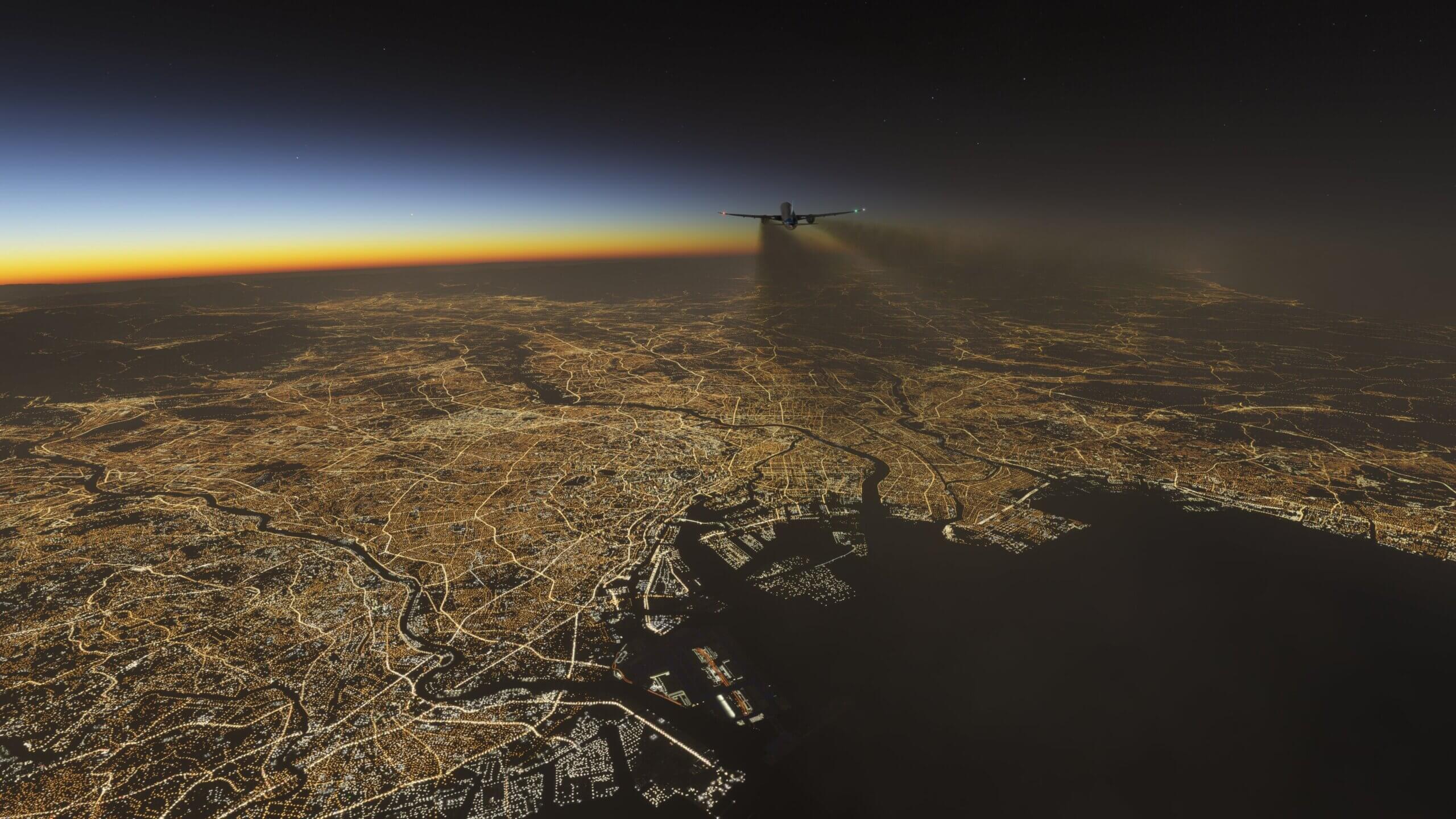 An airliner in cruise over a city lit up at night