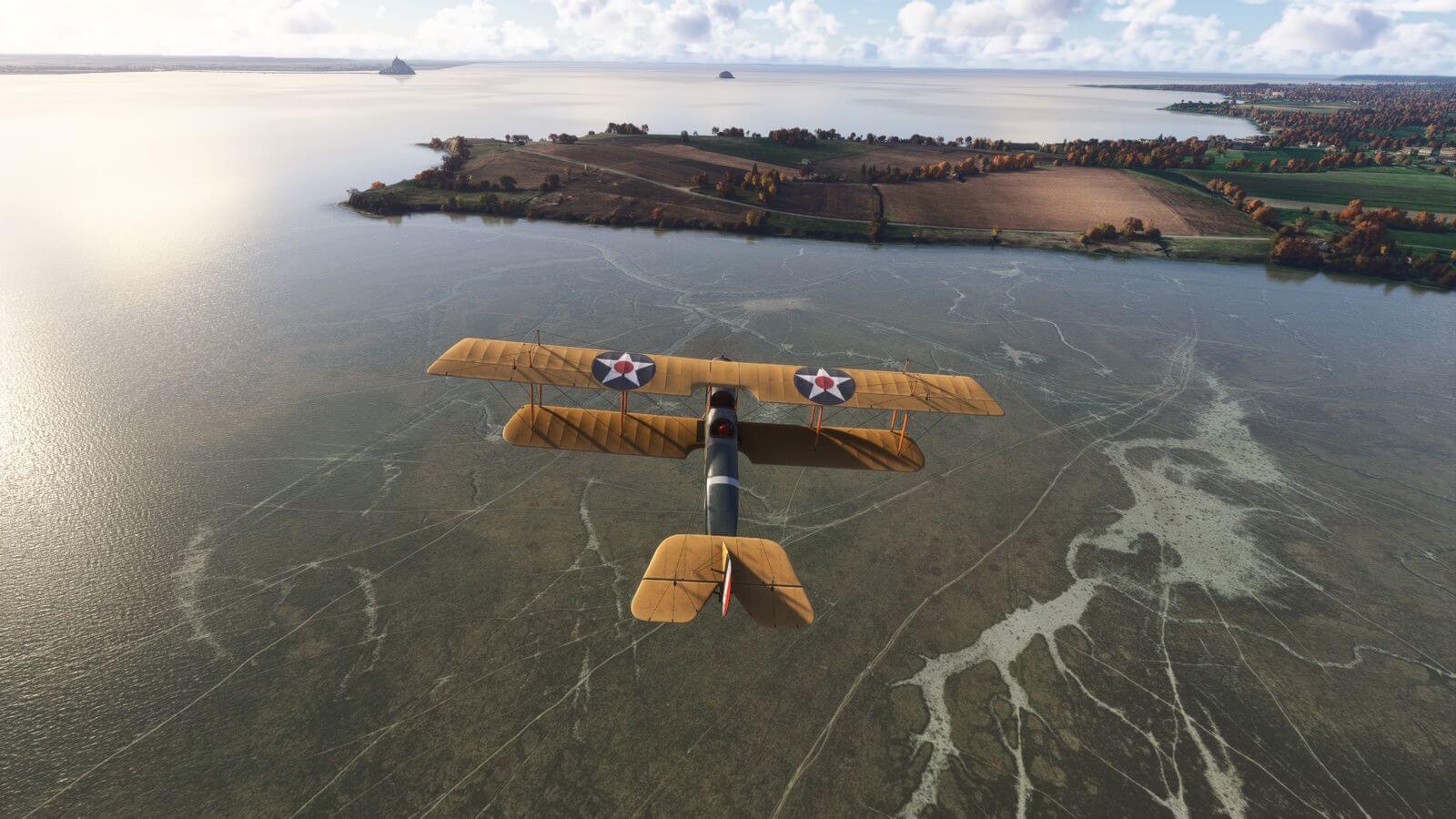 A dual wing propeller retro aircraft flies low towards a grass airstrip