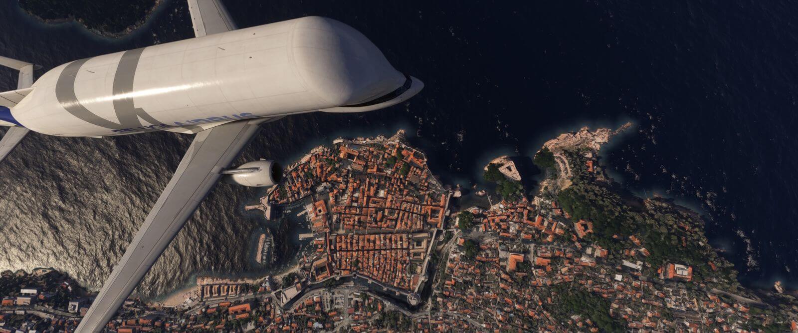 An Airbus Belga XL flies over a coastline city