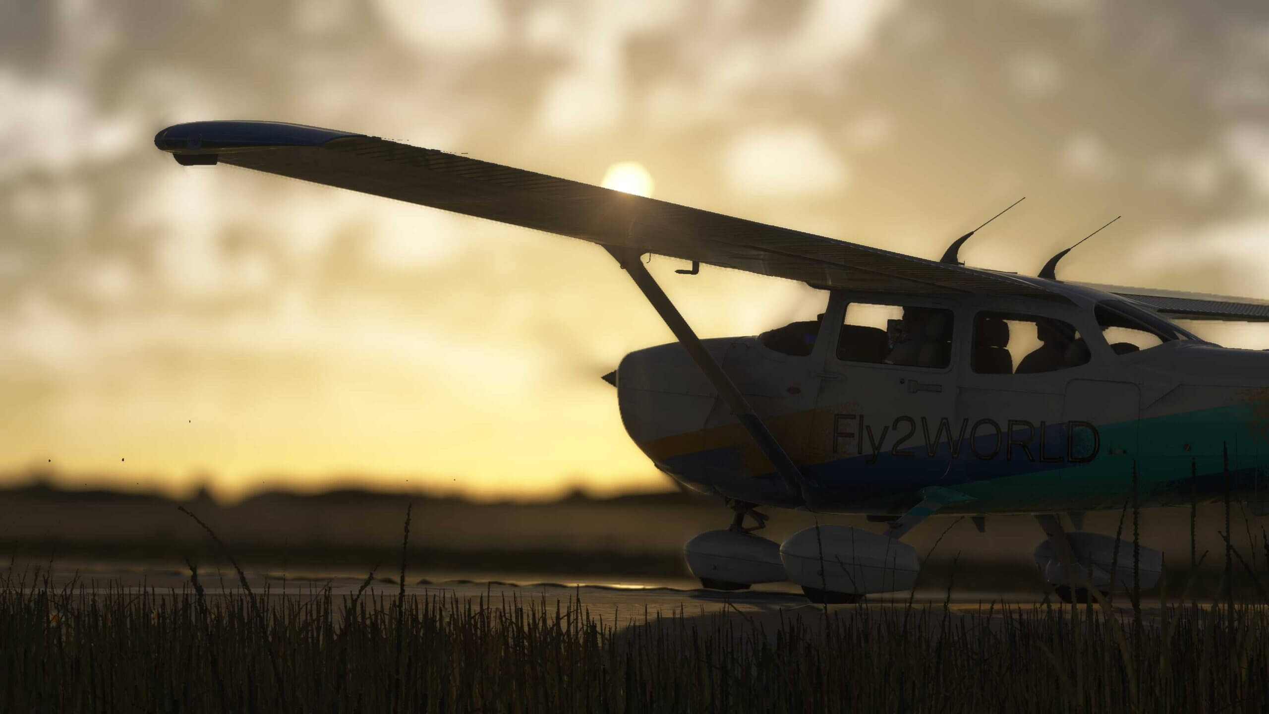 A Cessna 172 taxis at an airport with the sun in view behind