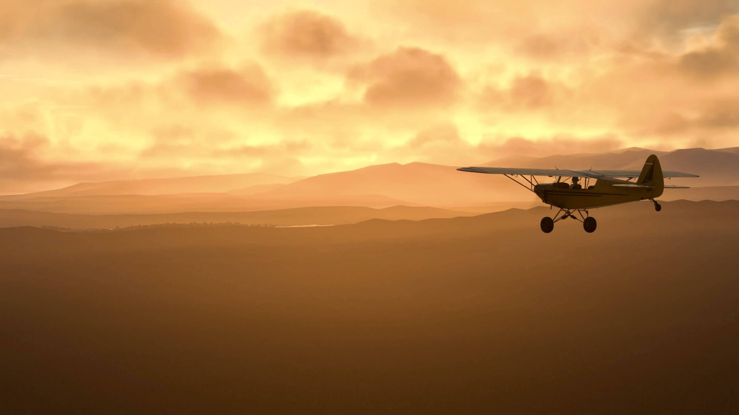 A yellow high wing aircraft flies during sunset