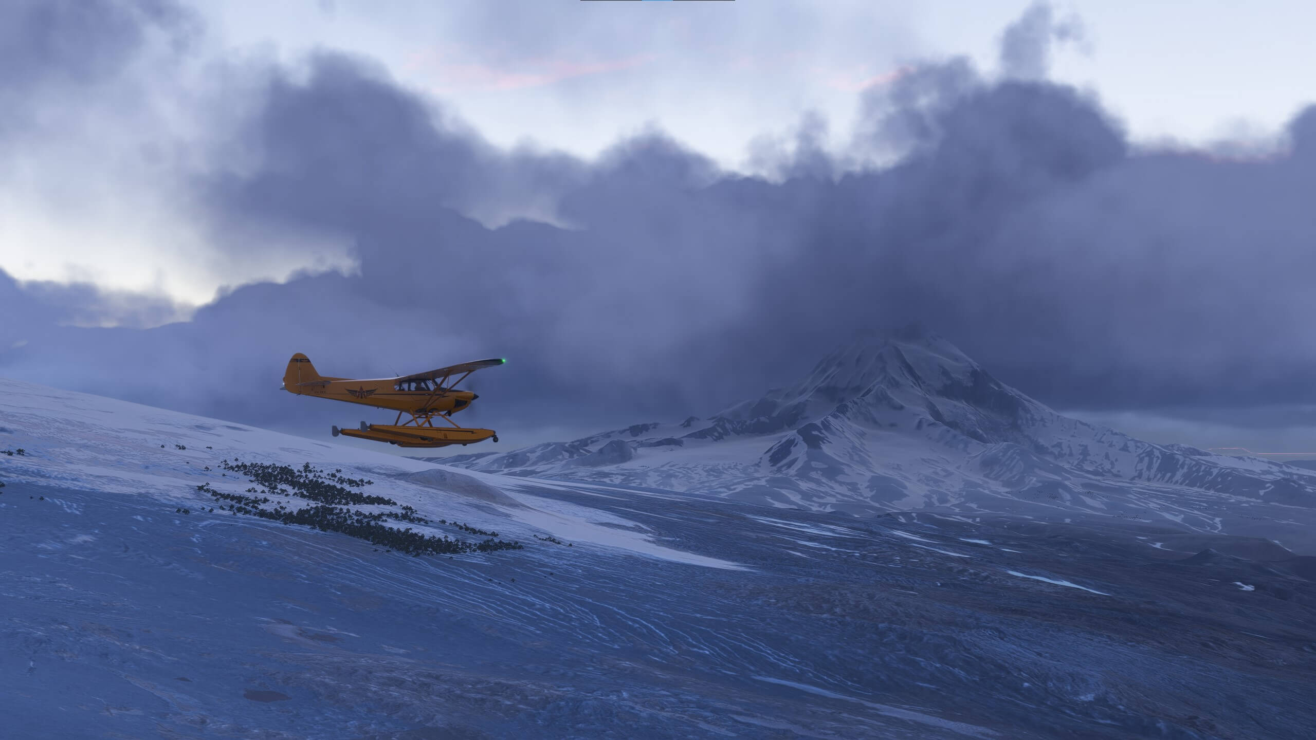 A yellow high wing aircraft flies near a snow covered mountain